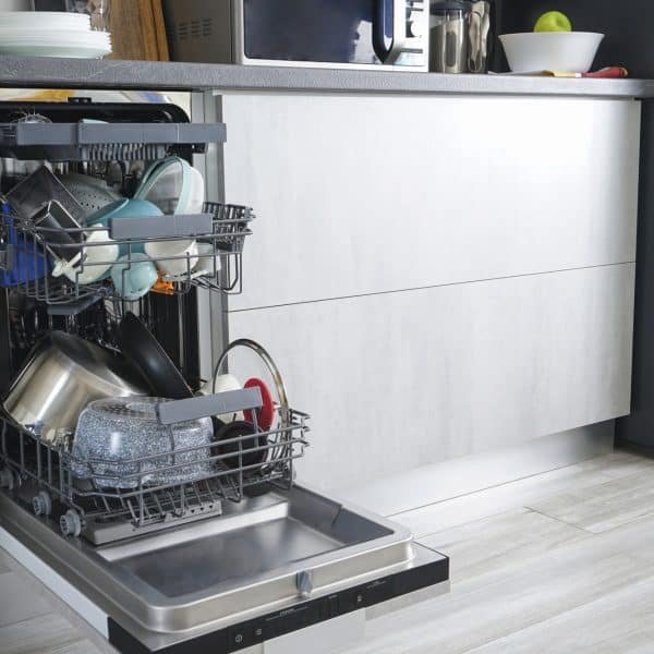 Dishwasher machine, open and loaded with dishes in the kitchen,